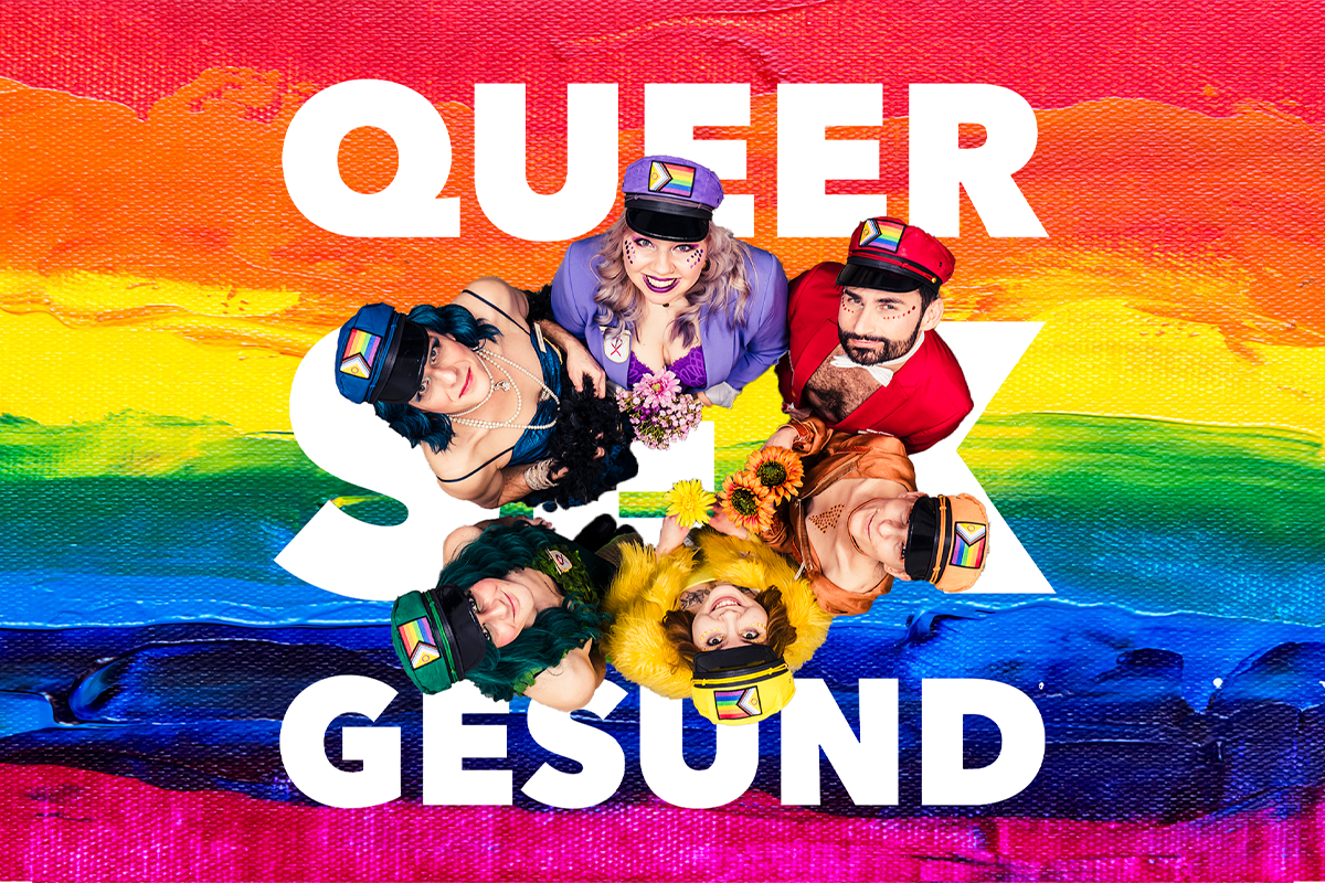 Regenbogen-Hintergrund und Menschen von oben fotografiert, die jeweils komplett in einer Farbe des Regenbogens angezogen sind